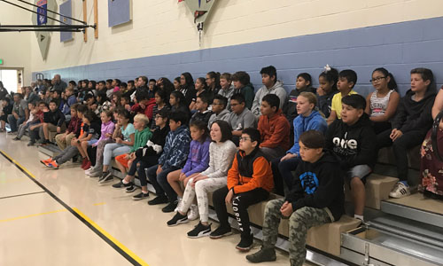 5th Grade students sitting on bleachers at 1st assembly 